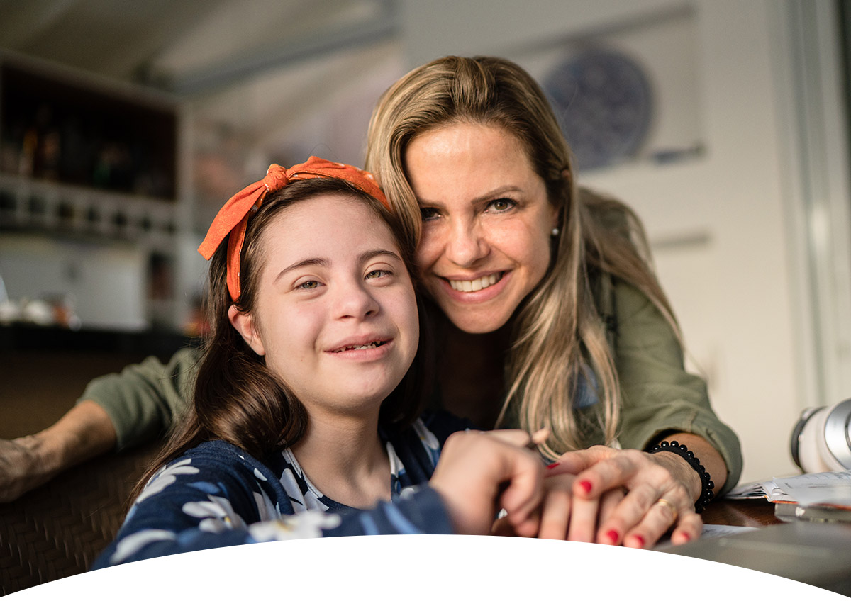 Betreuerin hilft behindertem Mädchen bei den Hausaufgaben